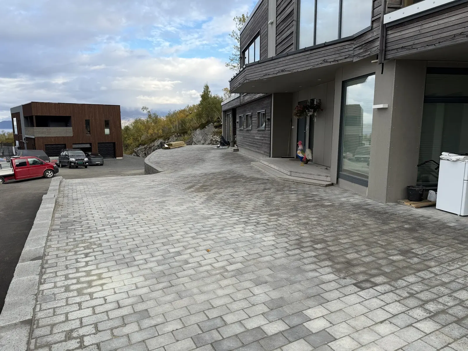 Brosteinlagt plass foran boliger med kantstein