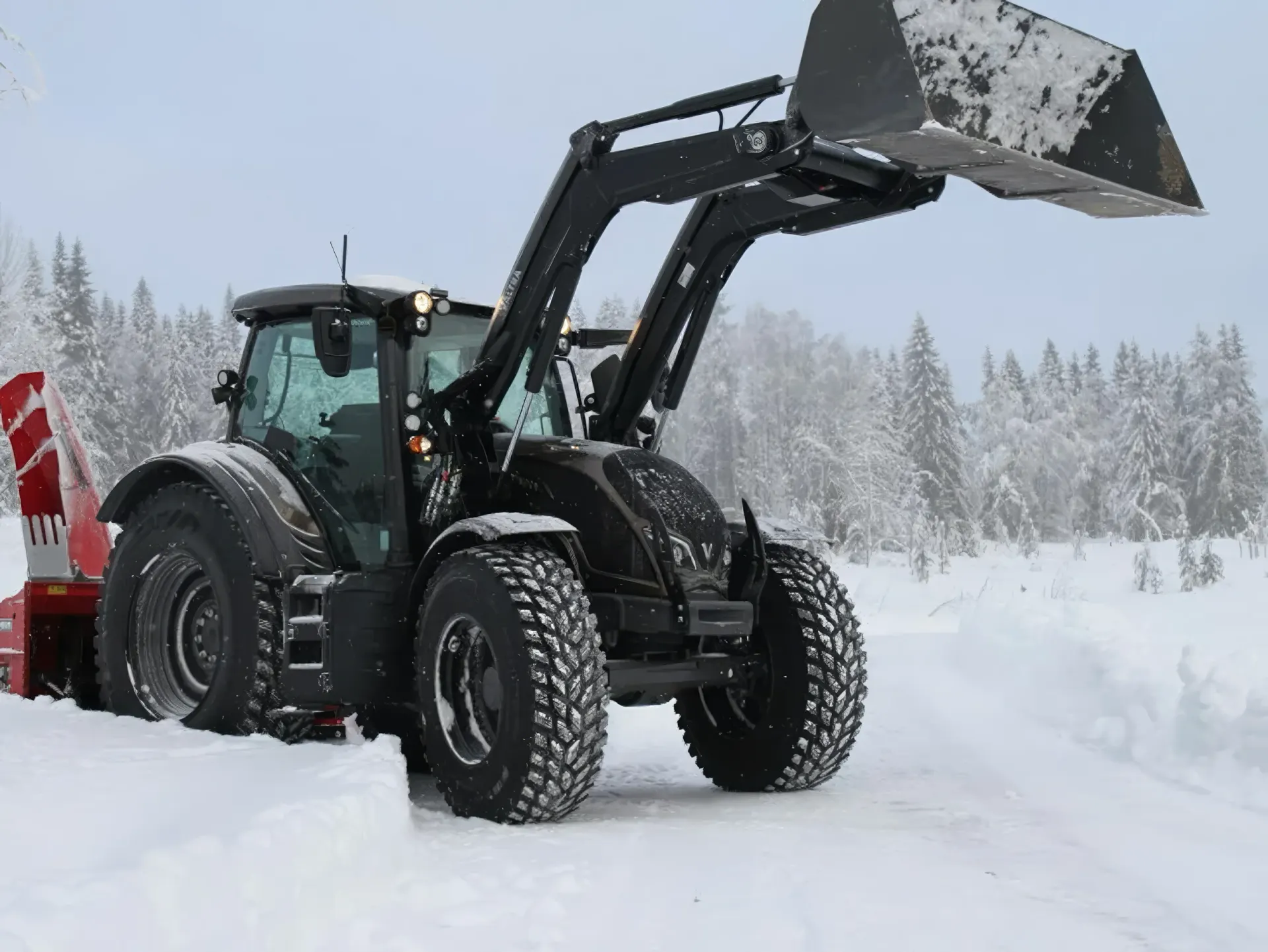 Traktor med frontlaster og snøfres på snødekt vei