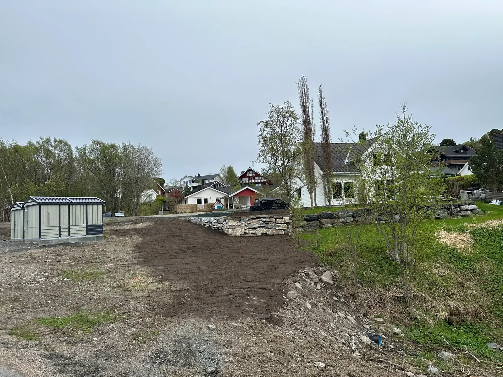 Opparbeidet garasjetomt med jord og grus i et boligfelt