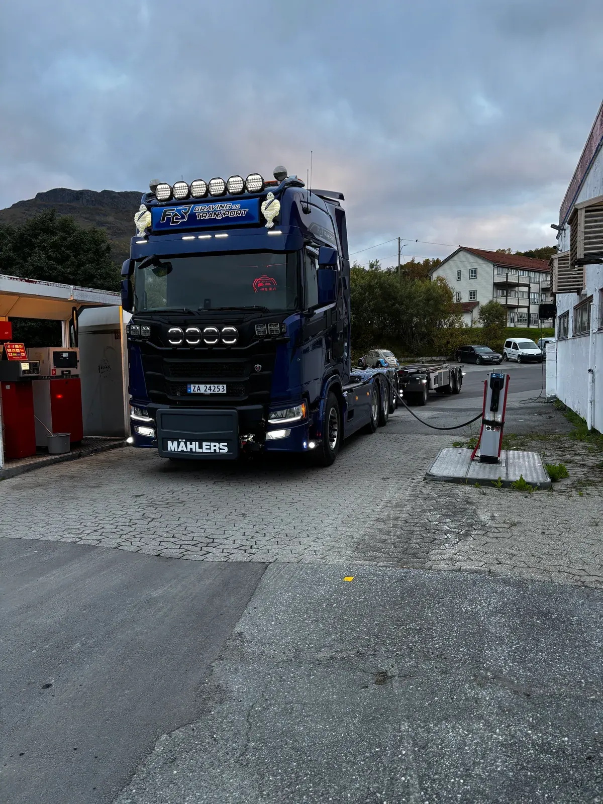 Blå krokbil i en gate i et boligområde