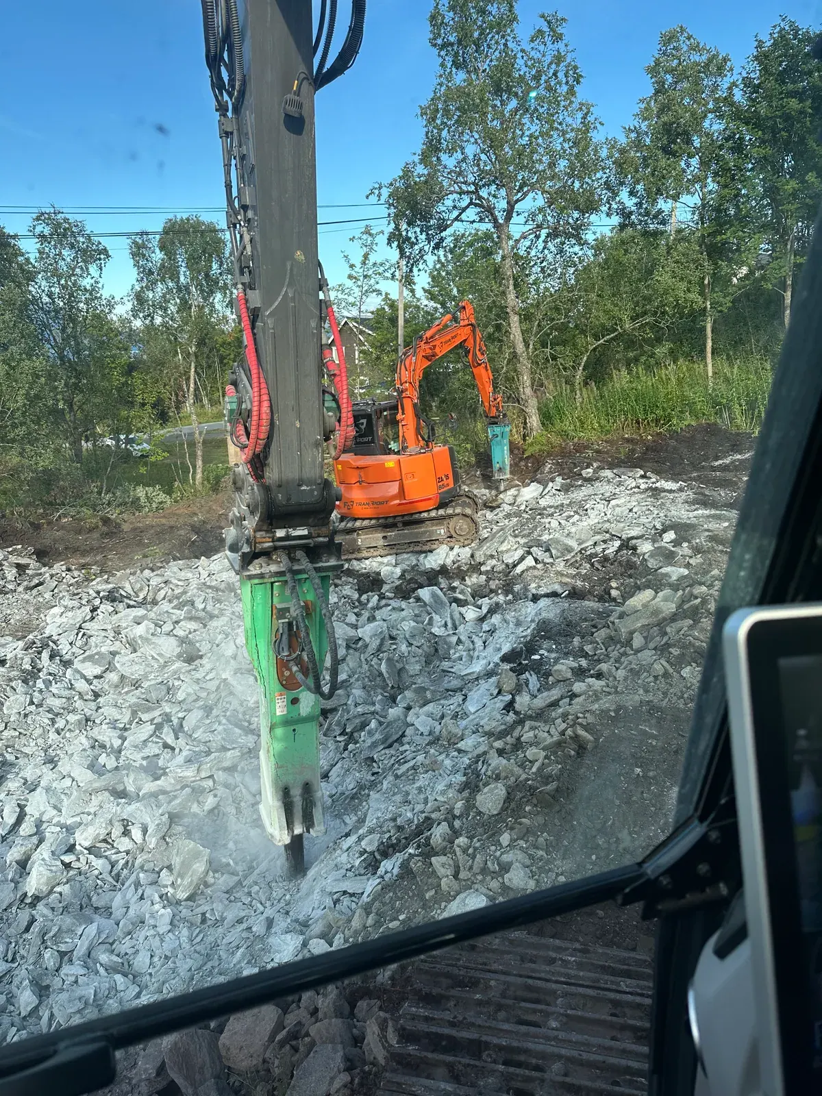 Gravemaskin med pigghammer på fjell
