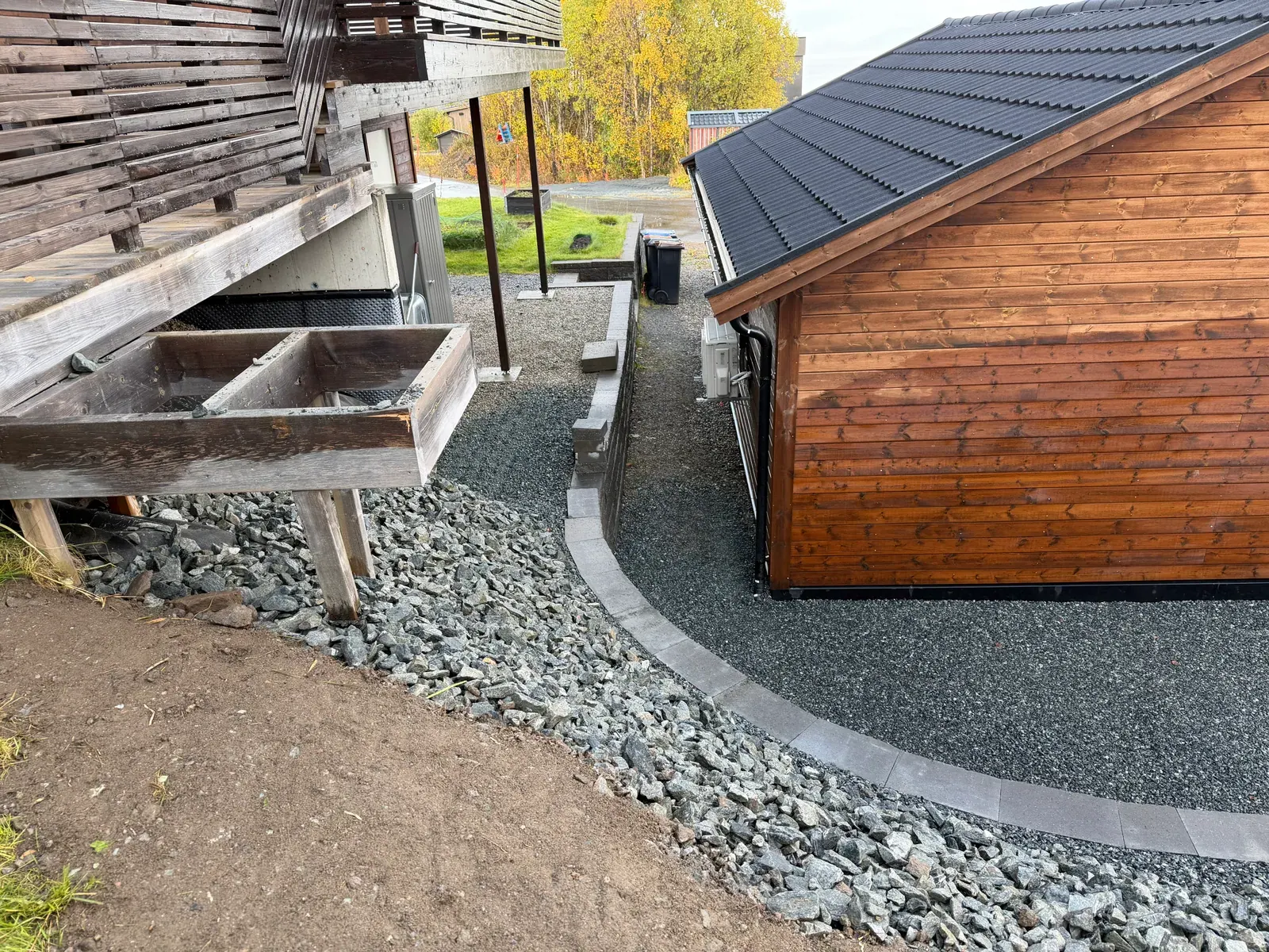 Støttemur og pukk langs en garasje