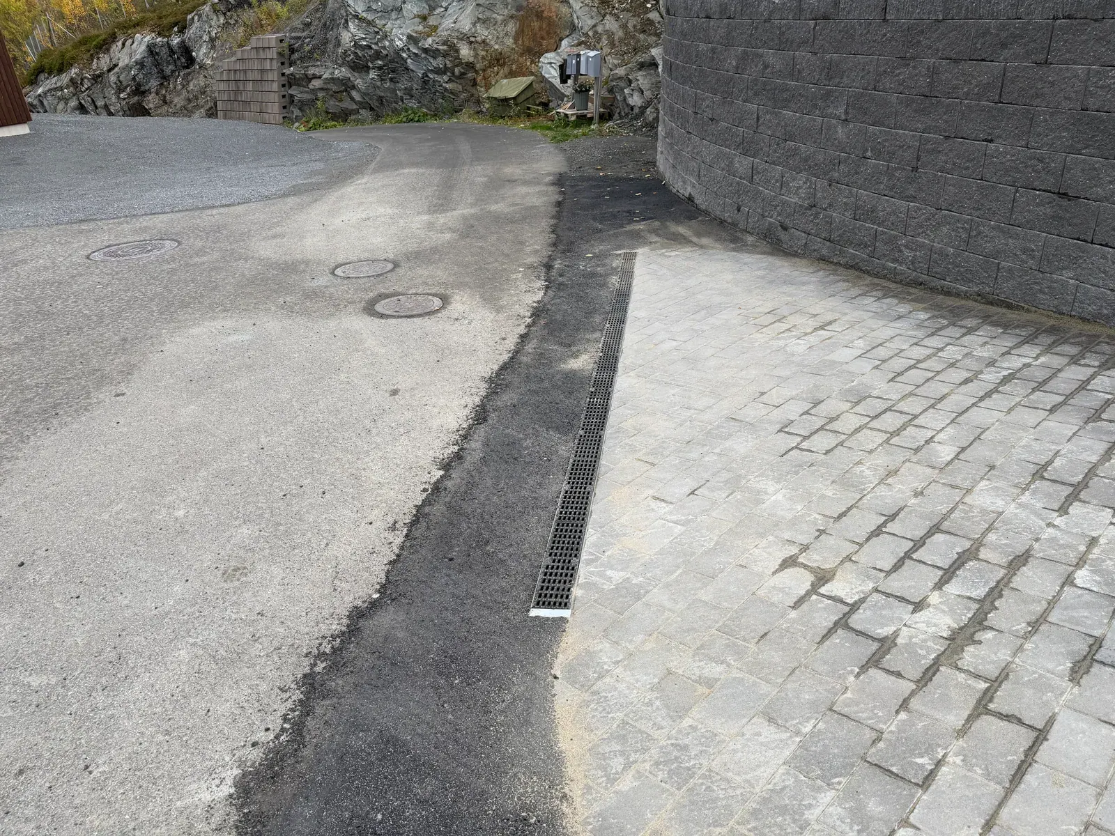 Belegningsstein med renne mot asfalt