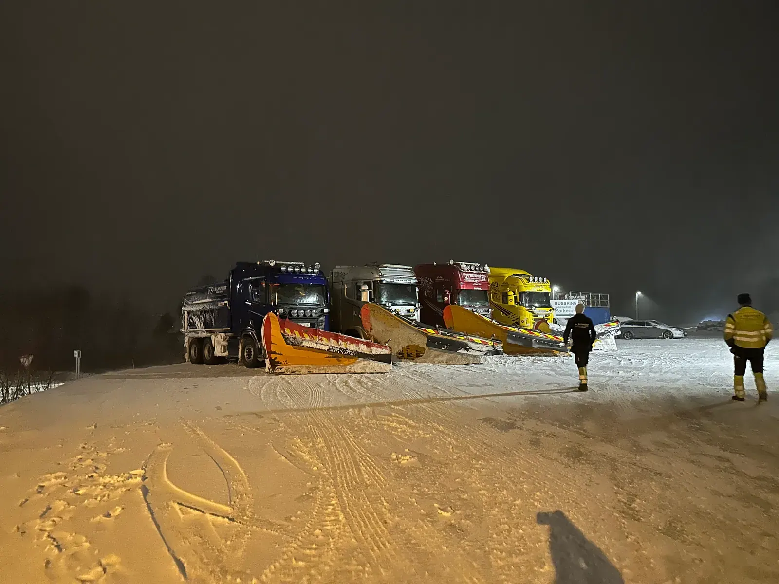 Brøytebiler med plog oppstilt om kvelden